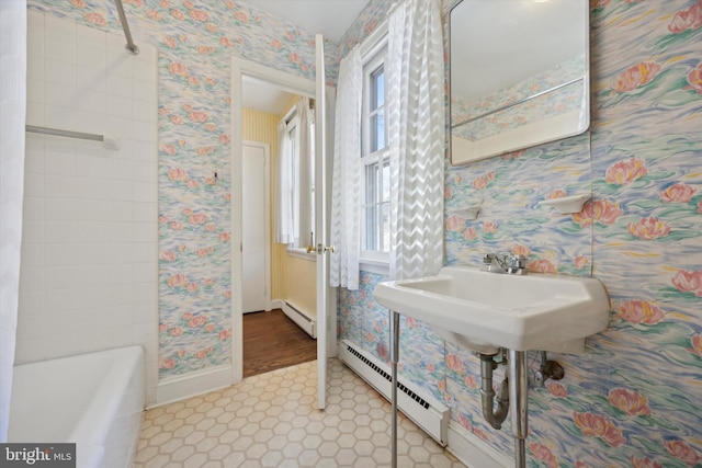 full bathroom featuring wallpapered walls, a baseboard radiator, baseboards, and a bath