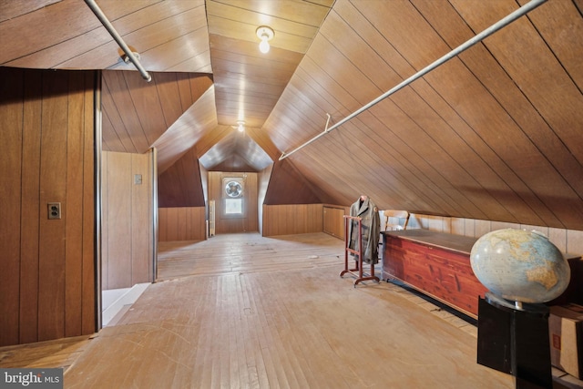 additional living space with lofted ceiling, wood walls, wooden ceiling, and hardwood / wood-style flooring