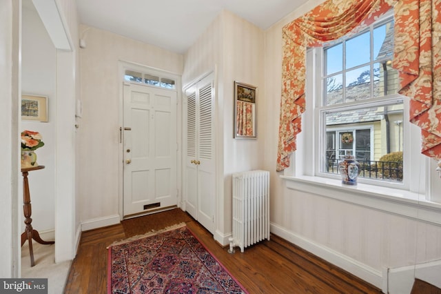 entryway featuring radiator heating unit, wood finished floors, and baseboards