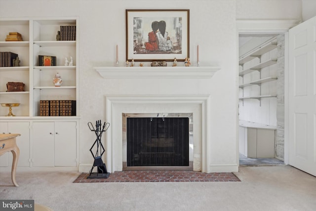 unfurnished living room with carpet floors, built in features, and a fireplace with flush hearth