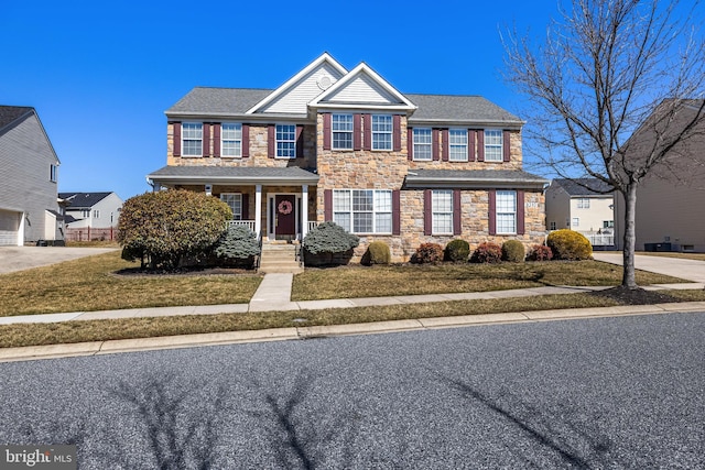 view of front of property featuring stone siding and a front yard