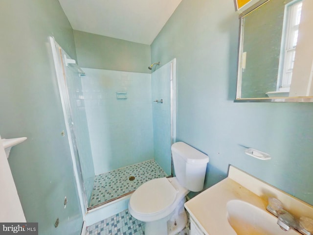 bathroom featuring tile patterned floors, a shower stall, toilet, and vanity