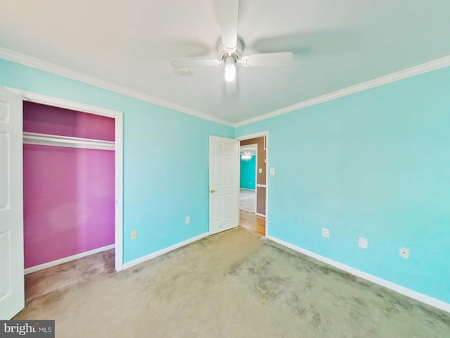 unfurnished bedroom with ornamental molding, carpet flooring, a ceiling fan, and baseboards