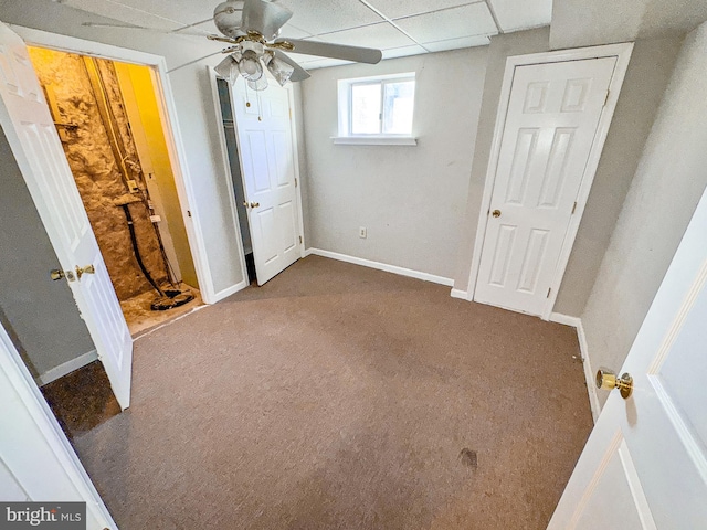 unfurnished bedroom with carpet floors, a ceiling fan, baseboards, and a paneled ceiling