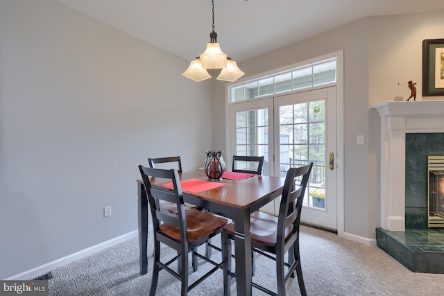 dining room with a fireplace, carpet flooring, and baseboards