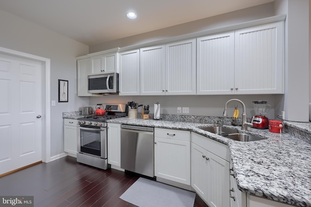 kitchen with dark wood-style floors, white cabinetry, appliances with stainless steel finishes, and a sink