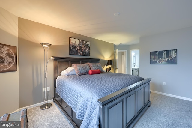 bedroom featuring light carpet, connected bathroom, and baseboards