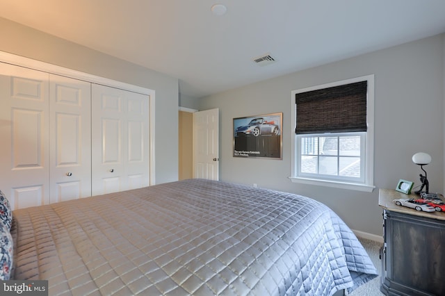 carpeted bedroom featuring a closet, visible vents, and baseboards