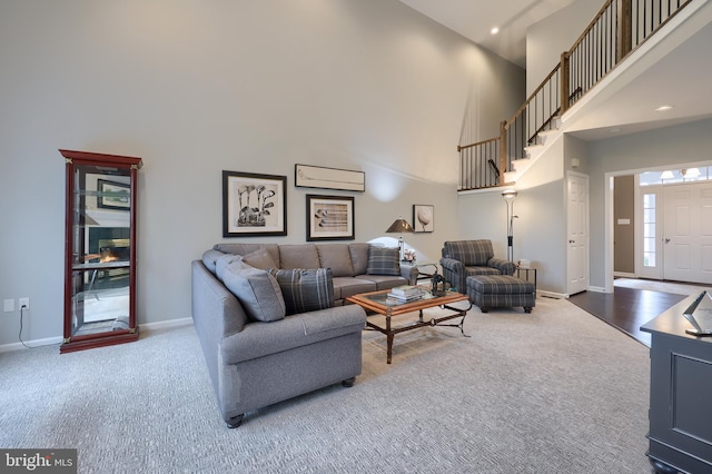 carpeted living room with a high ceiling, recessed lighting, and baseboards