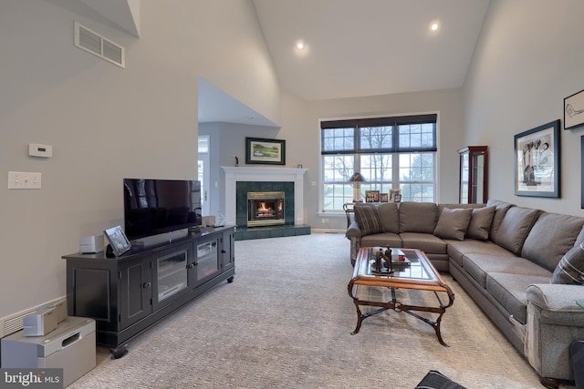 living area featuring recessed lighting, light colored carpet, visible vents, high vaulted ceiling, and a tile fireplace