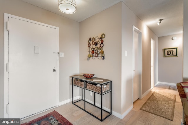 entryway featuring baseboards and light wood-style floors