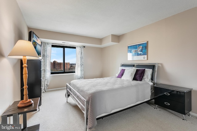 bedroom featuring light colored carpet and baseboards