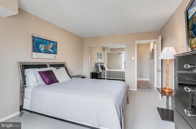 bedroom featuring light carpet, baseboards, and a closet