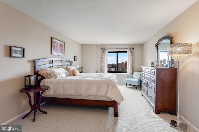 bedroom with light colored carpet and baseboards