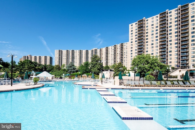 pool featuring a view of city, a patio area, and fence