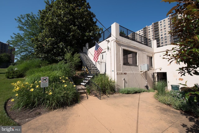 view of side of home featuring stairway and stucco siding