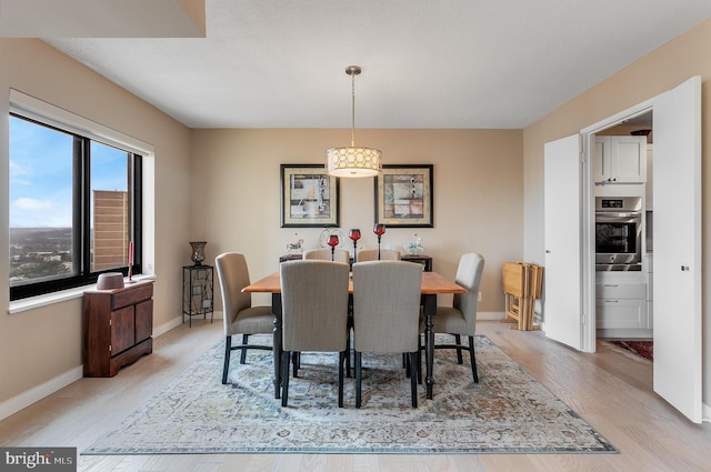 dining space with light wood-style floors and baseboards