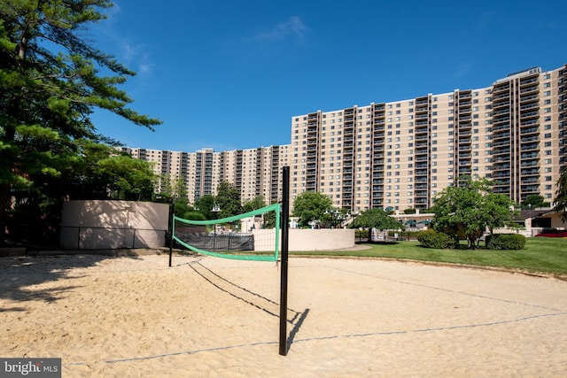 surrounding community featuring a city view, fence, and volleyball court