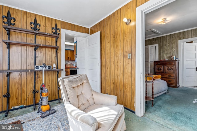 living area with wood walls, attic access, and crown molding