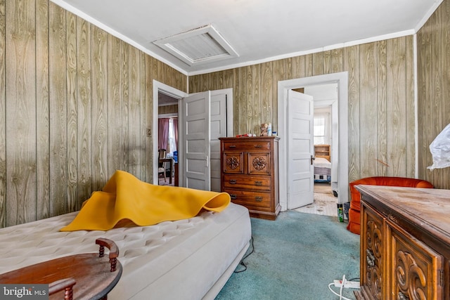 bedroom with wood walls, attic access, visible vents, and carpet flooring