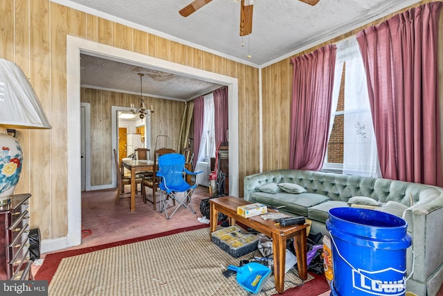 interior space with ornamental molding, carpet flooring, ceiling fan, wooden walls, and a textured ceiling