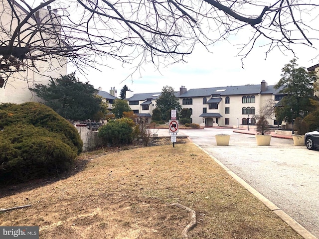 view of road featuring traffic signs, a residential view, and curbs