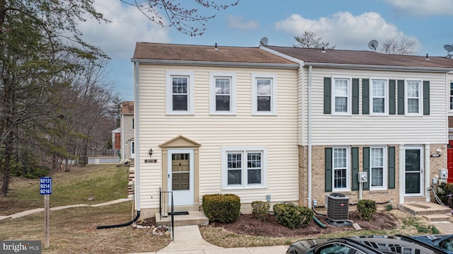 view of property featuring a front yard and central air condition unit