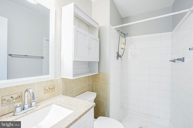 full bathroom featuring toilet, tile walls, a stall shower, and vanity