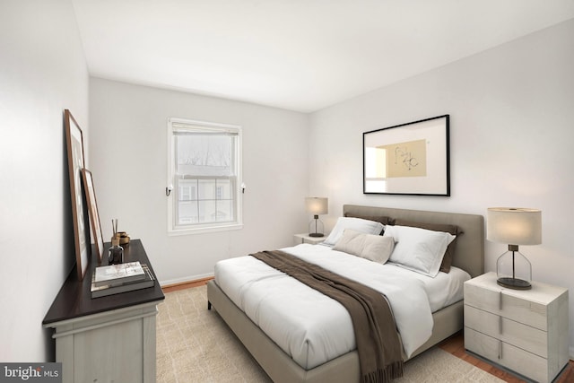 bedroom with baseboards and light wood finished floors