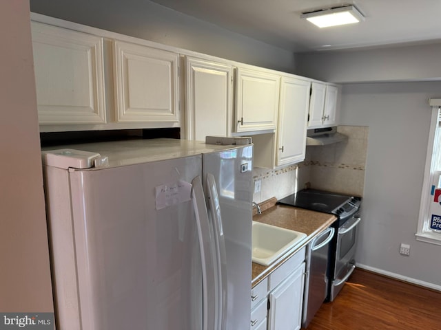 kitchen featuring under cabinet range hood, dark wood finished floors, decorative backsplash, stainless steel appliances, and white cabinetry