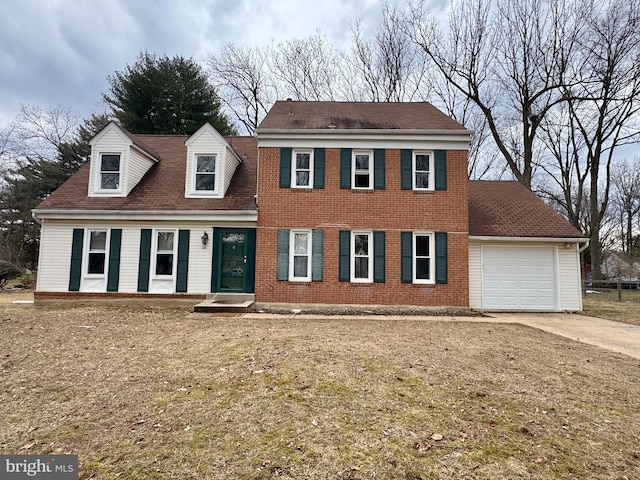 colonial house featuring a garage, concrete driveway, and brick siding