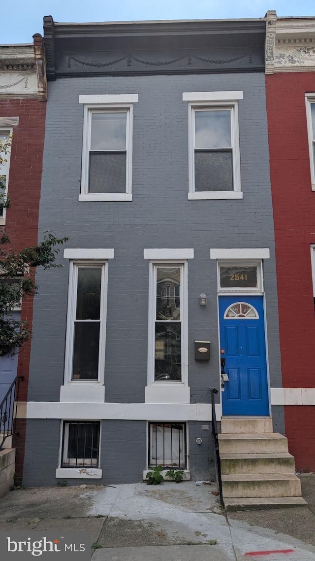 view of property with entry steps and brick siding