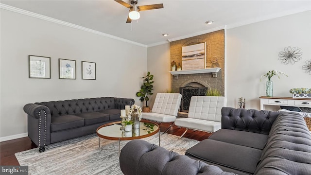 living area with a fireplace, wood finished floors, crown molding, and a ceiling fan