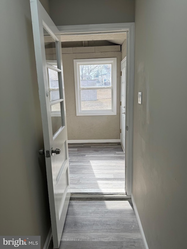 hall featuring wood finished floors and baseboards