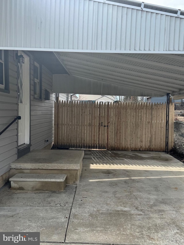 view of parking with a carport and fence