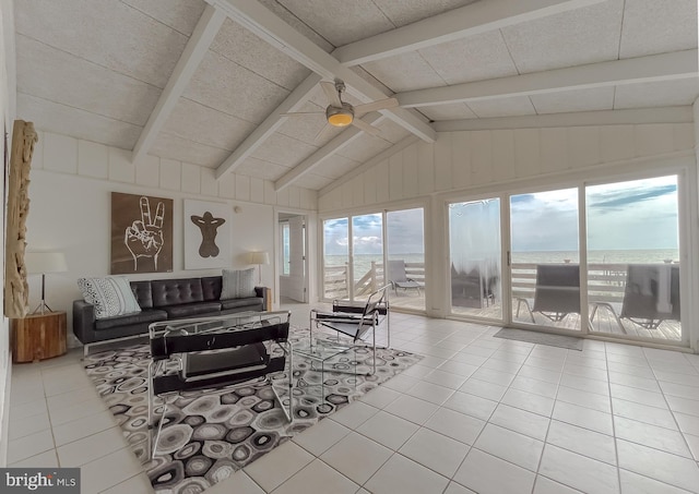 living room featuring a water view, light tile patterned floors, ceiling fan, and lofted ceiling with beams