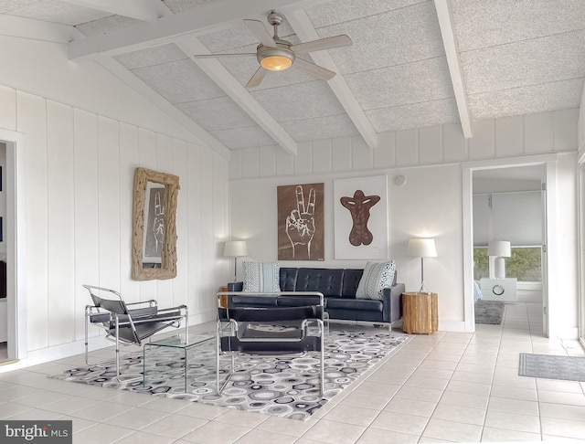 living area with lofted ceiling with beams, ceiling fan, and tile patterned floors