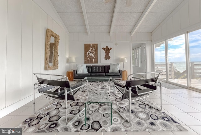 living room featuring a water view, lofted ceiling with beams, and light tile patterned floors