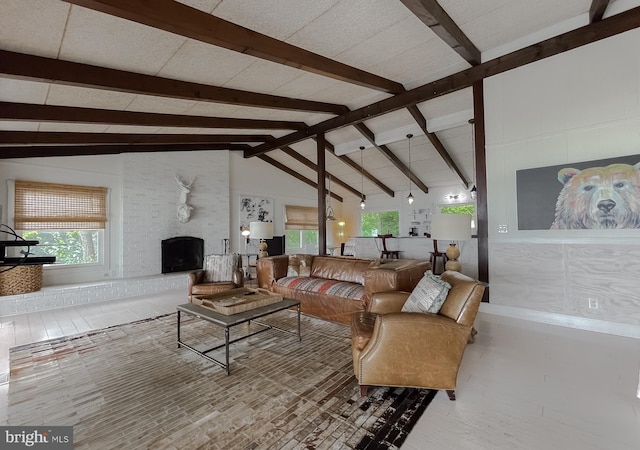 living area with a fireplace, high vaulted ceiling, and beam ceiling