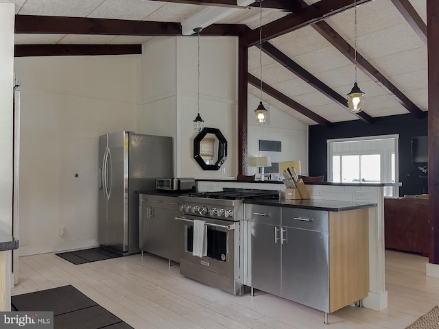 kitchen featuring appliances with stainless steel finishes, dark countertops, open floor plan, and decorative light fixtures