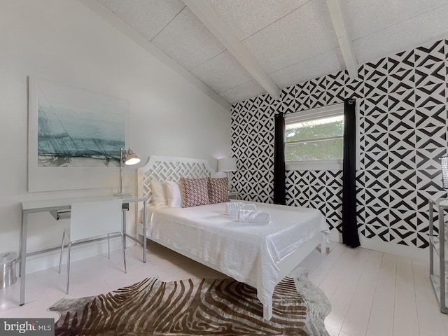 bedroom with vaulted ceiling with beams and light wood finished floors