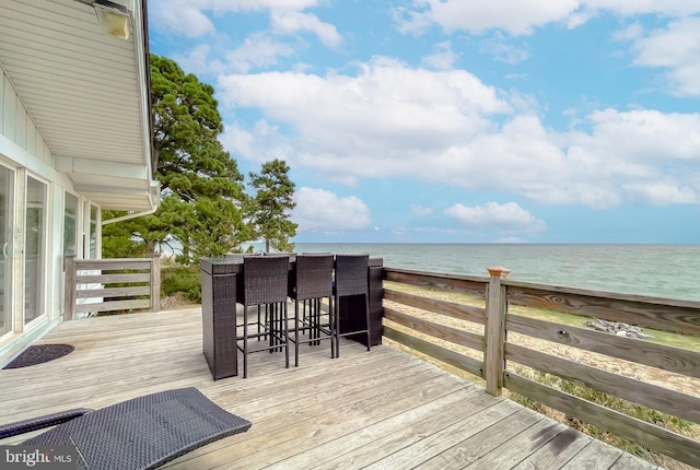 wooden deck with a water view and a view of the beach