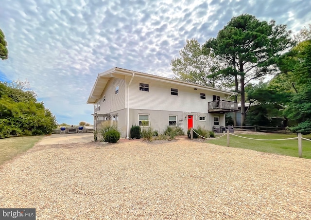 back of house featuring driveway and stucco siding