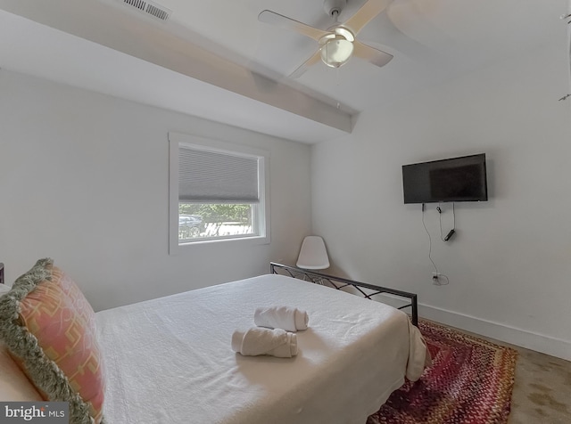 carpeted bedroom featuring a ceiling fan, visible vents, and baseboards