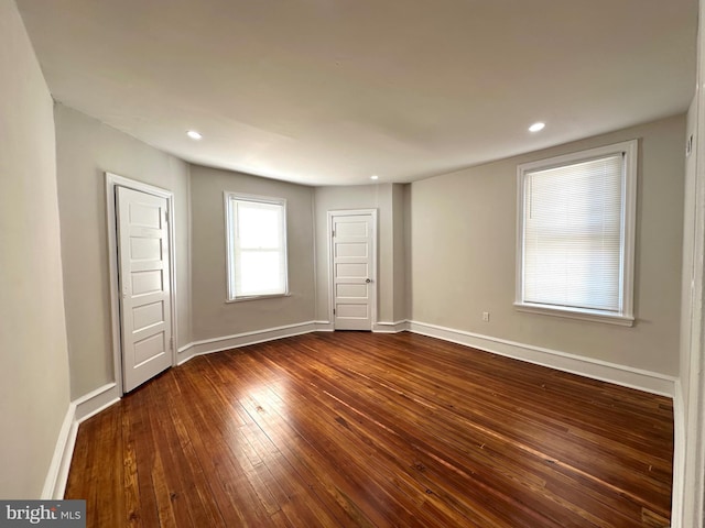 spare room with dark wood-style floors, recessed lighting, and baseboards