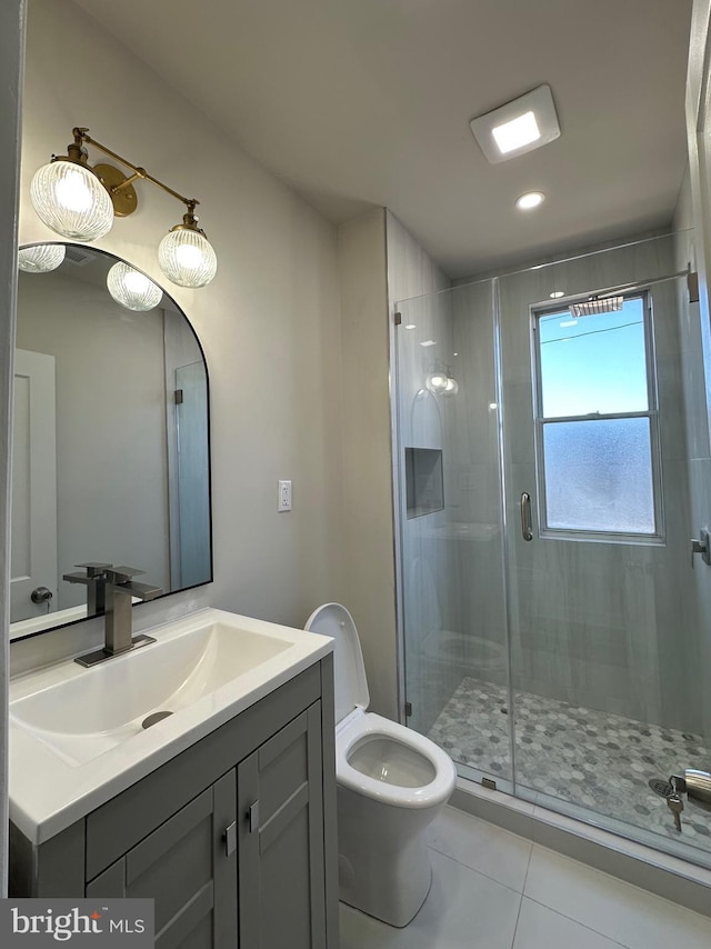 full bathroom featuring toilet, a shower stall, tile patterned flooring, and vanity