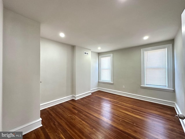 unfurnished room featuring dark wood-style floors, recessed lighting, visible vents, and baseboards