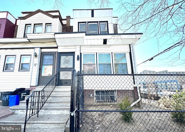 view of front of property with entry steps and a fenced front yard