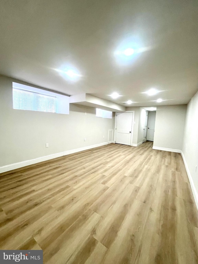 basement with light wood-style flooring and baseboards