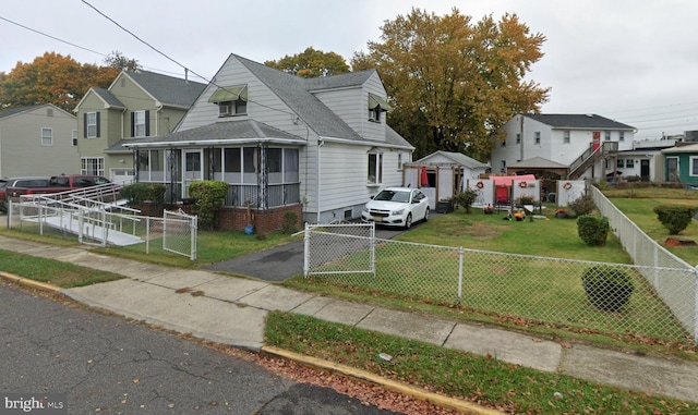 view of front facade with aphalt driveway, roof with shingles, fence, and a residential view